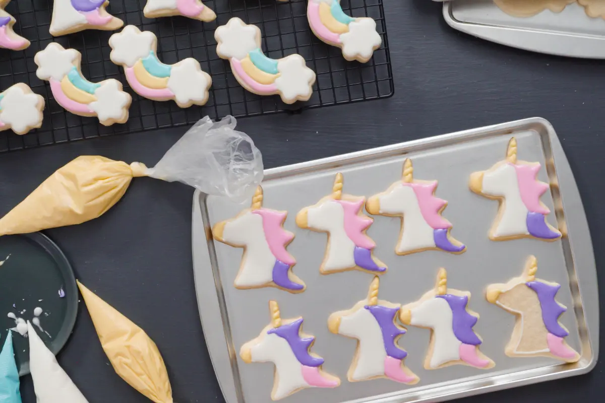 A tray of unicorn-shaped cookies with pastel icing, hand-decorated with care, ready to add enchantment to any festive occasion.
